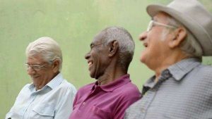 A group of three senior men laughing together as friends